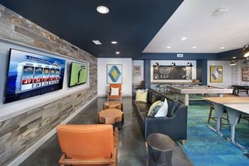 A recreation room with a shuffleboard table and couches